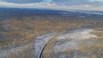 Aiereal wives of the road in winter forest with lot of trees and snow , drone shoot ,Ukraine 