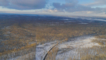 Aiereal wives of the road in winter forest with lot of trees and snow , drone shoot ,Ukraine 