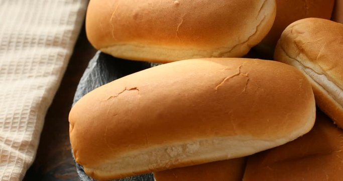 Fresh hot dog buns on a wooden surface rotation 360 4k