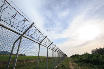 Fototapeta premium Chain link fence with grass field Phuket International Airport