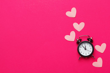 alarm clock and hearts on color background. Place for text.