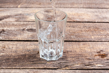 Glasses of water on a wooden table.