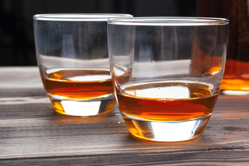 whiskey with ice cubes on wooden background