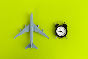 Time to travel concept. plastic plane jet toy passenger with alarm clock