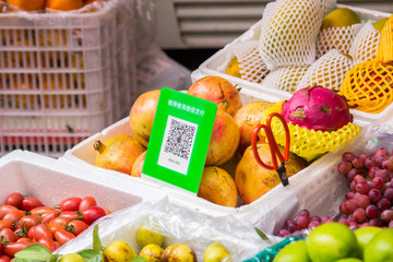Qr codes for cashless payment with smart phones stands over a vegetable booth Digitalization, such as cashless payment, in daily life is being widely accepted.