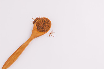 top view of a spoon of sandal wood with cinnamon on light background