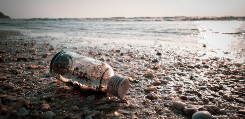 Fototapeta premium Sand and stone in Old bottle on the beach vintage instagram filter copy space for your text