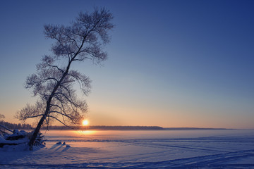 Fototapeta na wymiar Sunset on a frozen lake. Winter landscape.