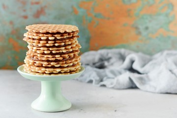 A stack of Dutch waffles with salted caramel on a gray background. Sweet waffle dessert.
