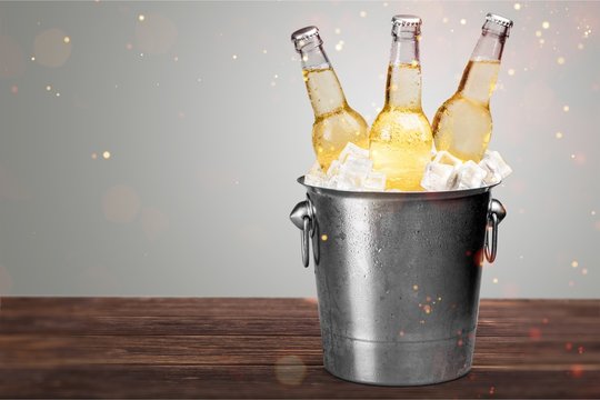 Beer Bottles in Bucket with ice cubes isolated on white