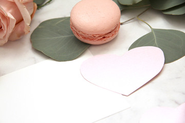 Composition for Valentine's day, pink rose, ribbon, heart, macaroons, eucalyptus, envelope, card, petals