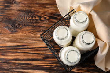 Obraz na płótnie Canvas Box with bottles of fresh milk on wooden table