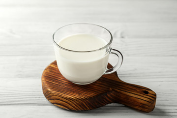 Glass cup of fresh milk on wooden table