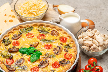 Baked homemade quiche pie in ceramic baking form, eggs and cream