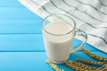 Glass cup of fresh milk on wooden table