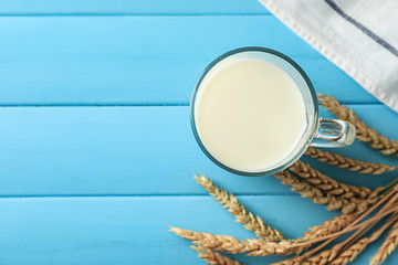 Glass cup of fresh milk on wooden table
