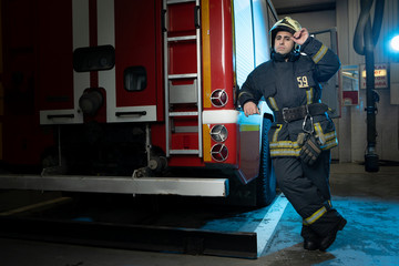 Full-length image of man firefighter at fire truck