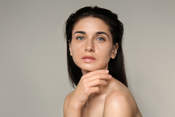 Portrait of beautiful young woman with natural makeup on light background