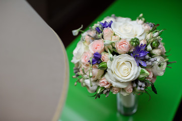 wedding bouquet of the bride on a green glass table in the hotel room