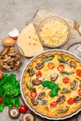 Baked homemade quiche pie in ceramic baking form, eggs and cream