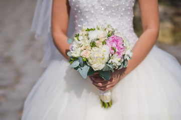 Obraz na płótnie Canvas wedding bouquet in the hands of the bride