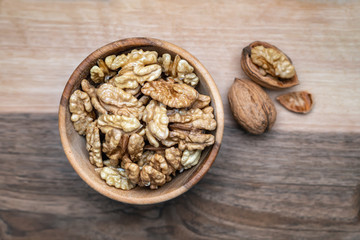 geknackte Walnusshälften in Holzschale von oben