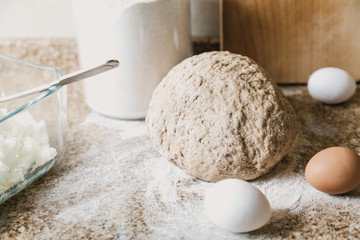 Kitchen still life. Dough, flour and eggs are on tabletop