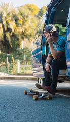 Man practicing with his long board on a lonely street in a sunset