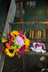 autumn bride's bouquet with sunflowers on a wooden staircase