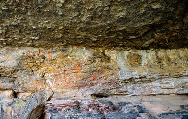 Fototapeta premium Ancient aboriginal primitive painting art on huge rock stone in Kakadu park, northern territory, Australia.