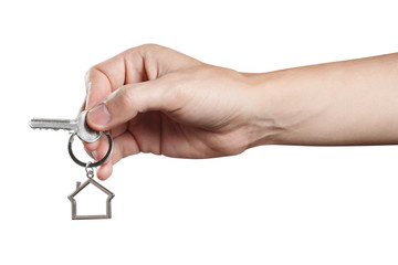 Hand holding a house key, isolated on white background