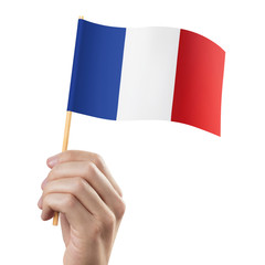 Hand holding flag of France, isolated on white background