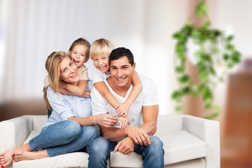 Fototapeta na wymiar Beautiful smiling family in room on couch