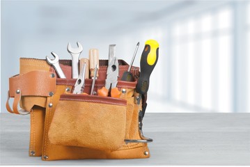 Tool belt with tools on wooden background
