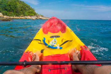Man sailing colorful kayak boat in the blue sea