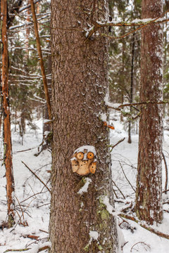 owl figurines made of wood in a winter forest 
