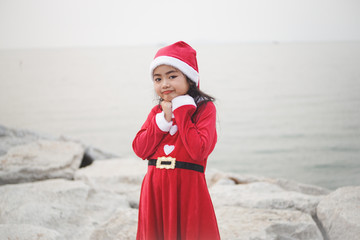 Obraz premium Little Asian girl in Santa Claus dress.Be smiling and played with camera.