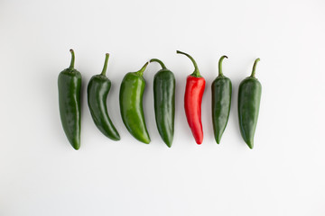 Green and red chillies in a line, one is red symbolising uniqueness