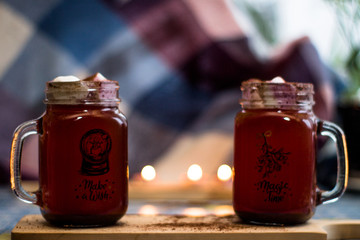 Mugs with chocolate and  ginger cookies on a wood desk with different lights