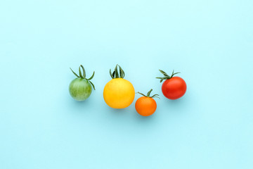 Colorful organic cherry tomatoes on a blue background, creative flat lay healthy food concept, top view