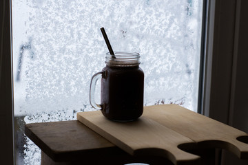 Mug of chocolate on a wood table near window