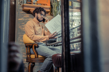 Busy young international businessman talking per telephone