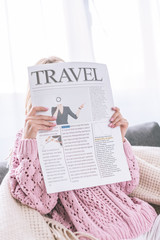 Naklejka premium woman reading travel newspaper while sitting at home