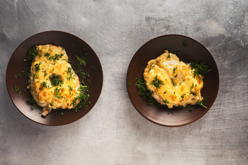 chicken fillet with pineapple, baked in the oven and topped with melted cheese. two portions