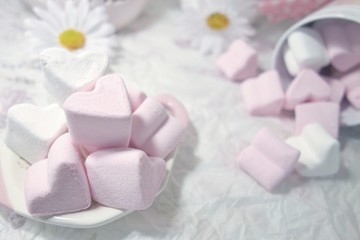 Fototapeta na wymiar Pink and White Marshmallow marshmallow in heart shape on the table . Pastel color dessert. Selective focus. Soft focus 