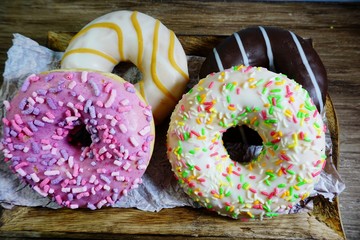 Colored delicious donuts . Glazed , colorful donuts on a table
