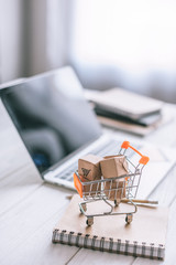 selective focus of decorative packages in toy cart on wooden desk