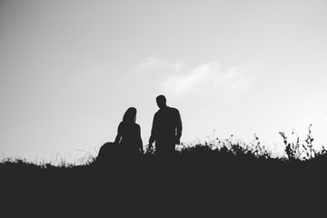 Silhouette of couple in love with wedding couple on top of a hill