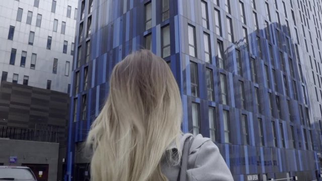attractive blonde business woman confident grey coat walking city