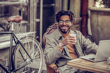 Positive delighted businessman looking straight at camera